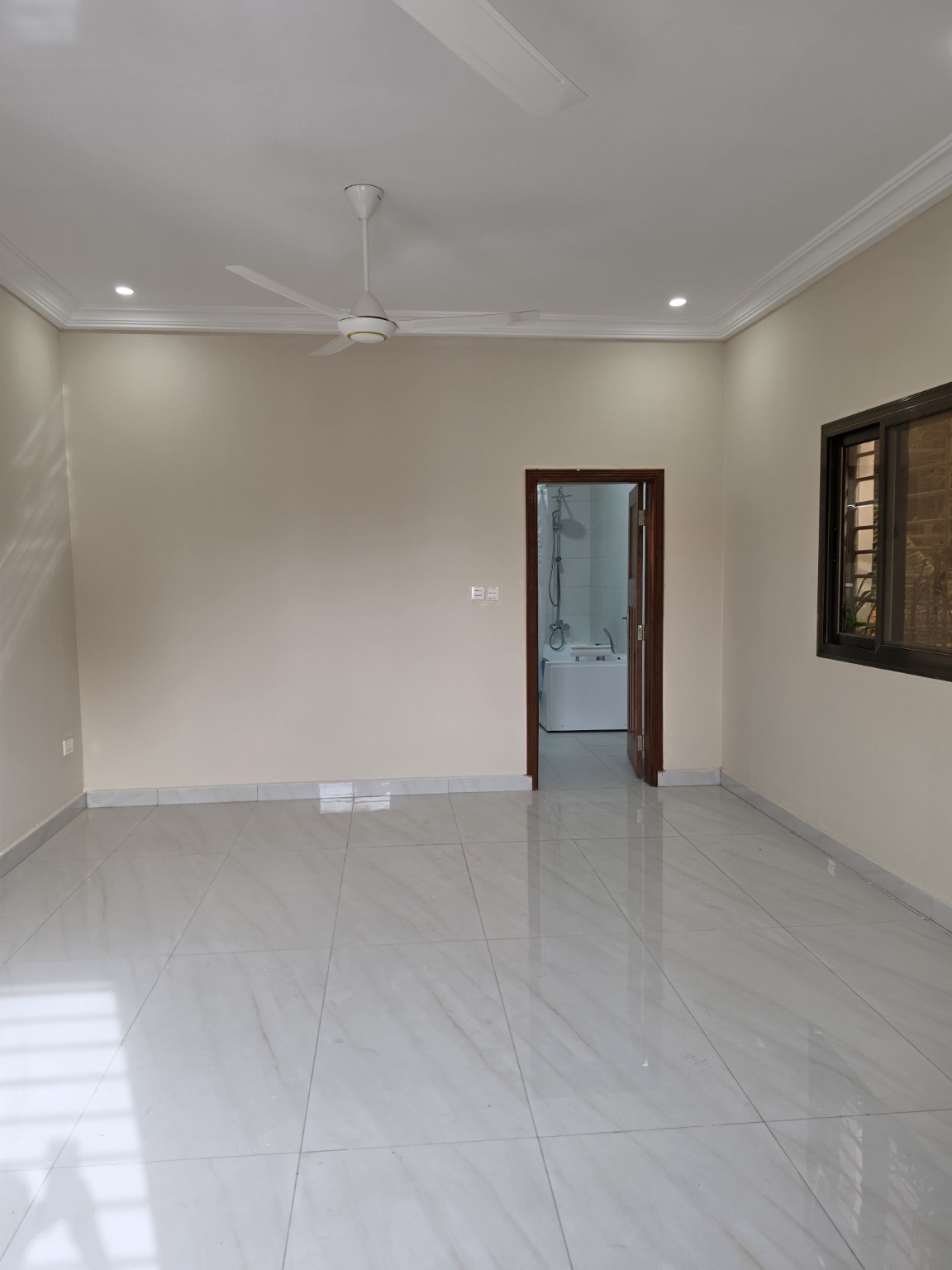 Bright en-suite bedroom with polished tiled floor